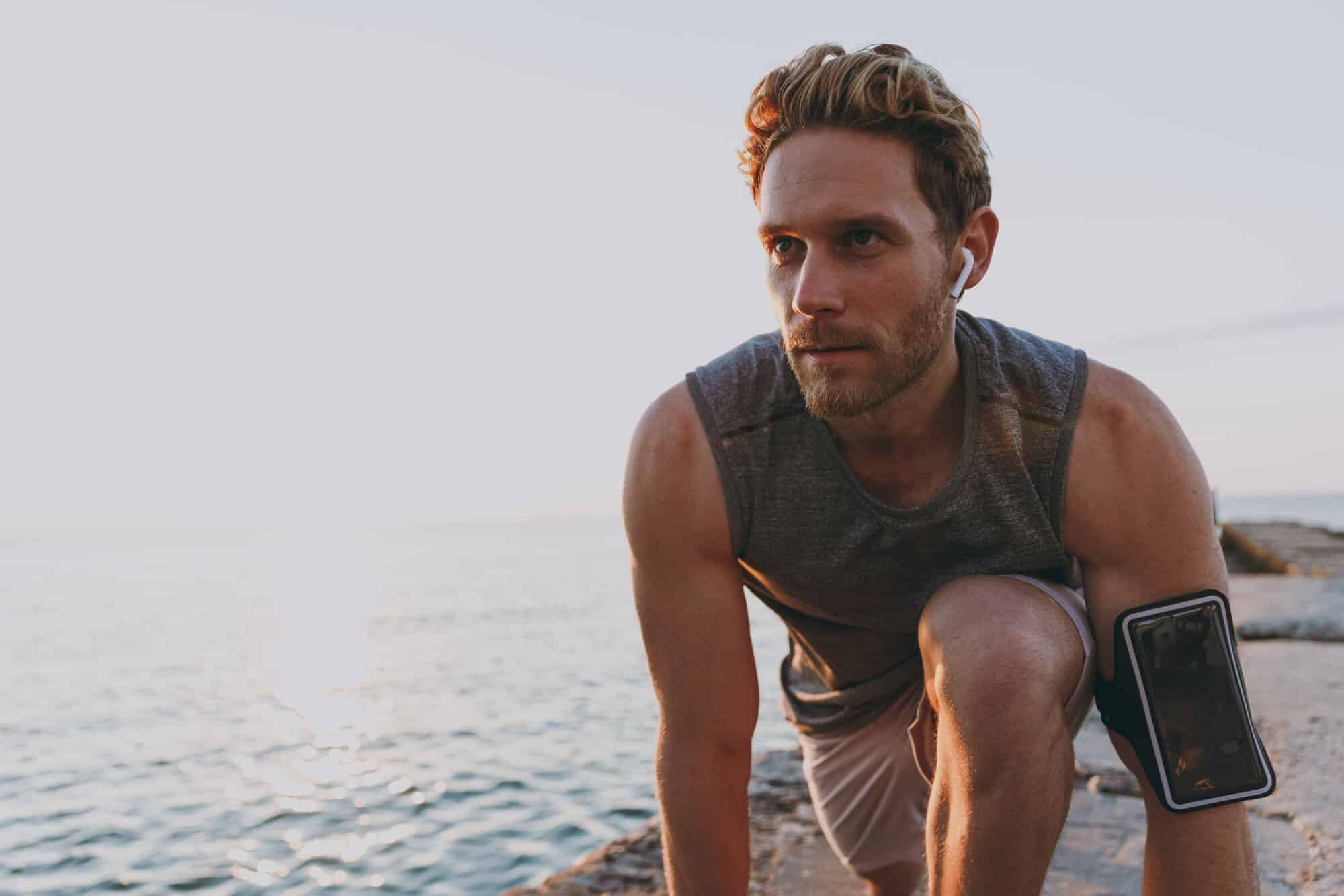 A man stretching along the beach with greater energy that to TRT with Enclomiphene Protocol At Mesa TRT